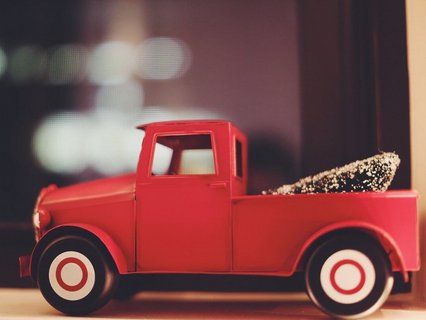 Rotes Spielzeugauto mit einem Weihnachtsbaum
